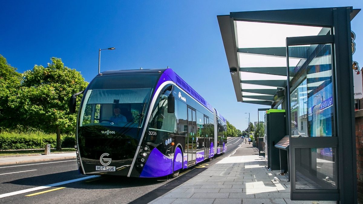 image of a new articulated glider bus pulling up to a stop